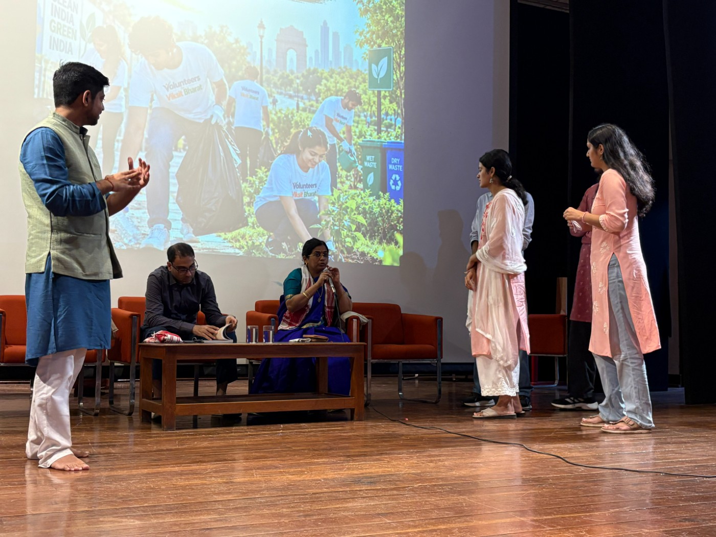 Manthan participants running a live simulation on stage, questioning a panel