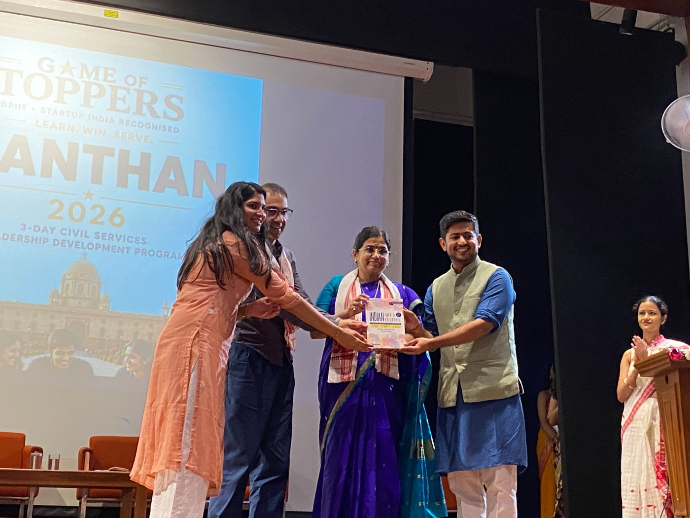 Manthan facilitators and guests presenting a book on stage