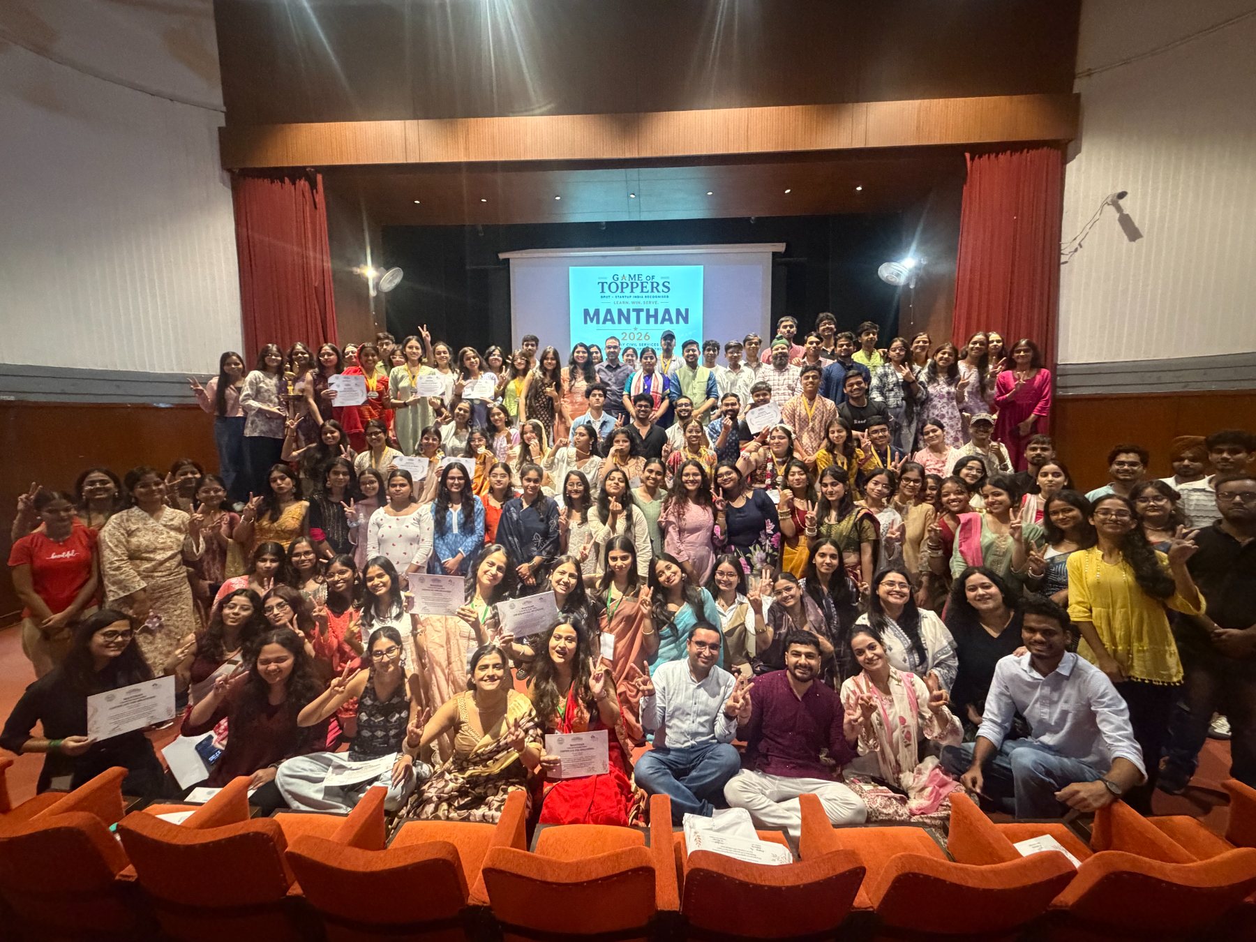The full Manthan 2026 cohort with facilitators in the auditorium, holding certificates